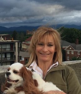 Dr Sondra Harry Smiling Holding Her Dog on a Rooftop